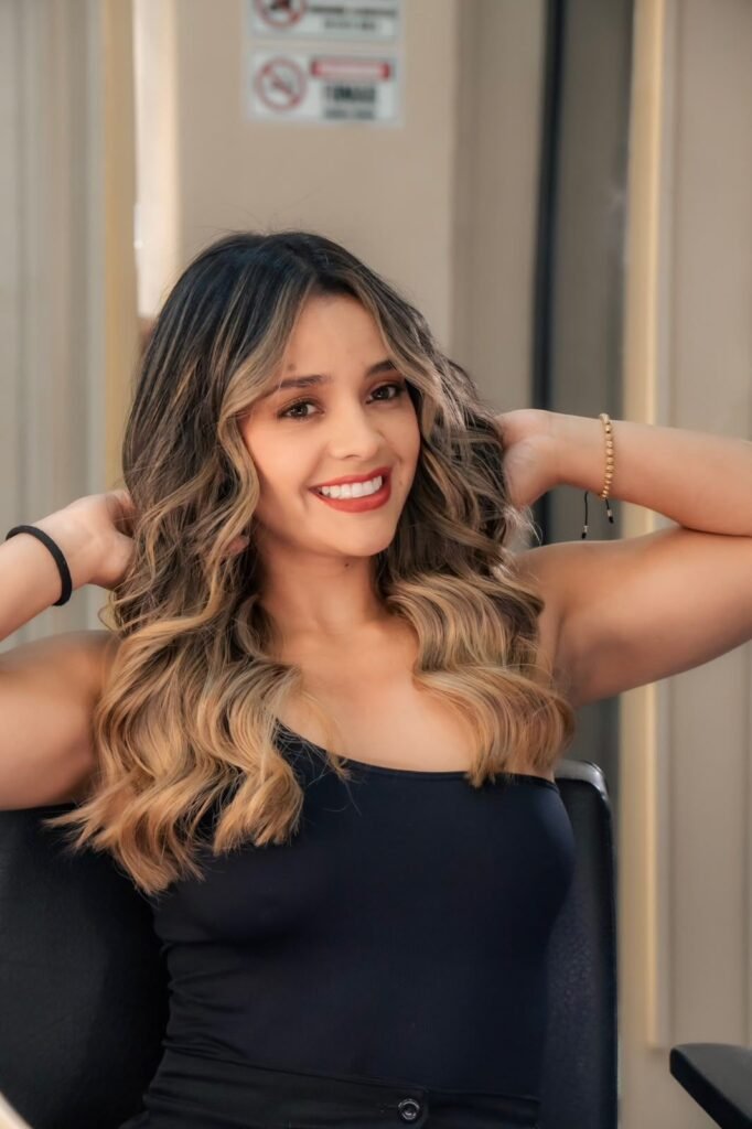 Soft caramel balayage vs highlights example: hand-painted color on long wavy hair
