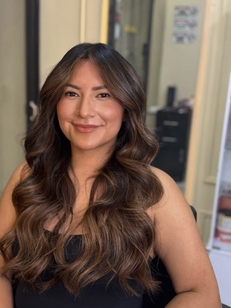 Balayage miel en cabello ondulado, ejemplo de balayage vs mechas en Medellín